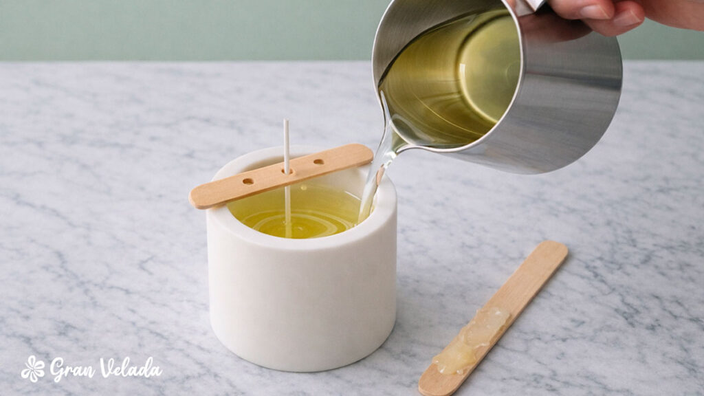 Vertimento de cera derretida num recipiente branco para fazer uma vela artesanal com pavio centrado