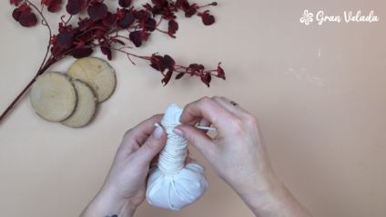 Atado de uma pinda de massagem relaxante com cordão de algodão, formando o cabo após o enchimento com plantas secas.